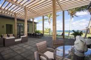 a patio with a table and chairs and the ocean at YellowBird home in South Palmetto Point