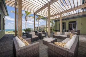 a patio with wicker chairs and tables and the ocean at YellowBird home in South Palmetto Point