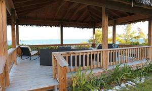 una terraza de madera con vistas al océano en YellowBird home, en South Palmetto Point
