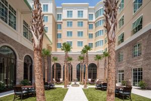 un patio con palmeras frente a un edificio en Embassy Suites by Hilton Charleston Harbor Mt. Pleasant, en Charleston