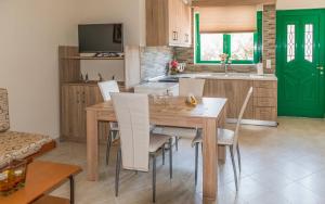 eine Küche mit einem Holztisch und weißen Stühlen in der Unterkunft Xirouchakis farm in Kissamos
