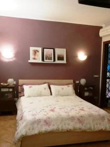 - une chambre dotée d'un lit avec 3 photos sur le mur dans l'établissement La Casa delle Ciliege, à Marcellina