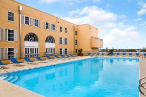 uma piscina num hotel com cadeiras e um edifício em Hilton New Orleans Riverside em Nova Orleães