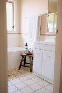 ein Badezimmer mit einem Waschbecken, einer Badewanne und einem Tisch in der Unterkunft Popular Central Location I NEW LINEN I Gated Estate I STAY DUBBO in Dubbo
