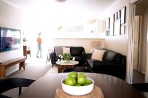 ein Wohnzimmer mit einem Tisch und einer Schale Äpfel in der Unterkunft Popular Central Location I NEW LINEN I Gated Estate I STAY DUBBO in Dubbo