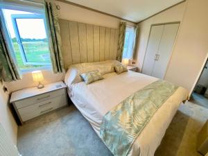 a small bedroom with a bed and a window at The Lodge in Selsey