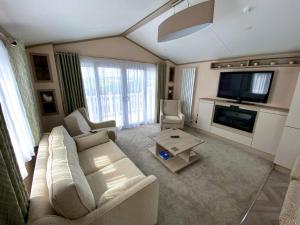 a living room with a couch and a tv at The Lodge in Selsey