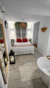a white bedroom with a bed and a bath tub at La Damajuana, Casa Rural in Montejaque