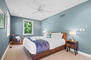 a bedroom with a large bed with blue walls at Blissful Boyne City Retreat: Luxurious & Modern! Sleeps 15! in Boyne City