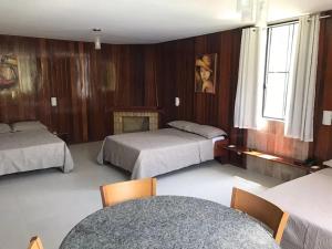- une chambre d'hôtel avec 2 lits et une cheminée dans l'établissement Auberge Valaisanne, à Santa Maria Madalena