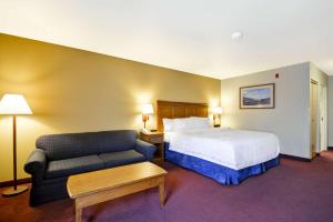 um quarto de hotel com uma cama e um sofá em Hampton Inn Bozeman em Bozeman