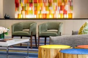 - une salle d'attente avec 2 chaises et des tables dans l'établissement Hilton Motif Seattle, à Seattle