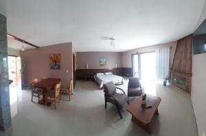 a living room with a bed and a table at Hotel Fazenda Valaisan in Santa Maria Madalena