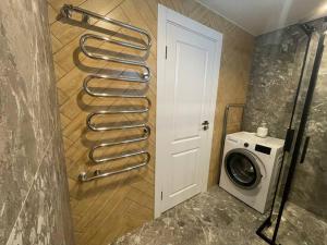 a bathroom with a drying rack next to a washing machine at Žemaičiai in Panevėžys