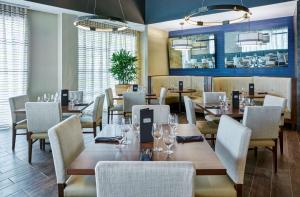 un restaurant avec des tables et des chaises en bois ainsi que des fenêtres dans l'établissement Doubletree by Hilton Charlotte Uptown, à Charlotte