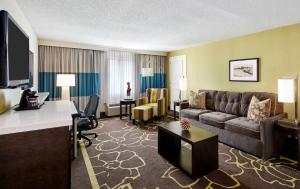 a hotel room with a couch and a living room at Doubletree by Hilton Charlotte Uptown in Charlotte