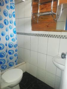 a bathroom with a toilet and a sink at SHERANPAZ in Oxapampa