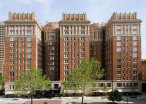 The Skirvin Hilton Oklahoma City في مدينة اوكلاهوما: مبنى من الطوب كبير مع طاولات أمامه