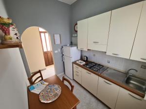 a small kitchen with a table and a stove at Casa Nautilus - 30m dal mare in Lampedusa