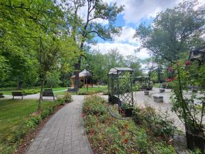 un parc avec un chemin, des bancs et des fleurs dans l'établissement Aquarius Kilińskiego 5, à Grodzisk Mazowiecki