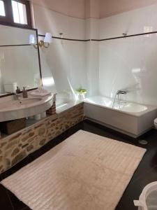 a white bathroom with a tub and a sink at Montaña y Campo "Remanso de Paz" in Castropodame