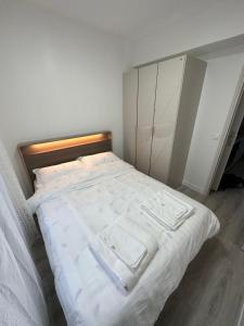 een slaapkamer met een wit bed en 2 handdoeken bij studio paris 12 in Parijs