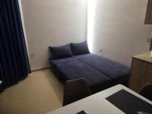 a small room with a blue bed and a desk at Seaside Luxury Apartments Kremasti in Kremasti