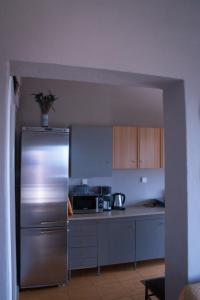a kitchen with a stainless steel refrigerator and cabinets at Your Holiday Apartment in Kavála +3 photos