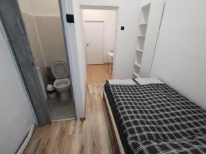 um pequeno quarto com uma cama e um WC em VasylOk em Varsóvia