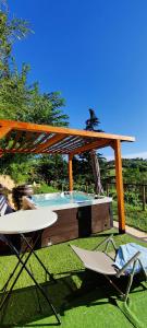 a swimming pool with two chairs and a wooden pergola at Le rose di Mapi in Mango
