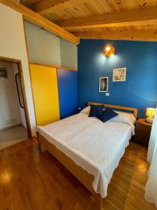 Schlafzimmer mit einem Bett mit blauen und gelben Wänden in der Unterkunft Valentina in Novigrad Istria