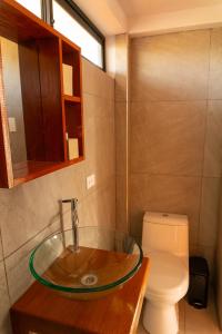 W łazience znajduje się szklana umywalka i toaleta. w obiekcie Che Lobitos w mieście Lobitos