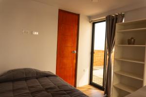 a bedroom with a bed and a door with a window at Che Lobitos in Lobitos