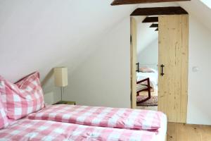 a bedroom with a pink bed and a mirror at Kellerstöckl - Am Vierkanthof 