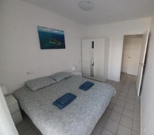 una camera da letto con un letto con due cuscini blu sopra di La Calma - one bedroom apartment by the pool in Playa Flamenca a Playas de Orihuela