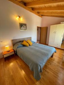 ein Schlafzimmer mit einem großen Bett mit gelben Kissen in der Unterkunft Valentina in Novigrad Istria