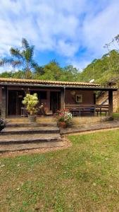 ein Haus mit einer Veranda und einem Picknicktisch in der Unterkunft Fazenda Quinta da Esperança- Pousada e Lazer in Tiradentes + 139 Fotos