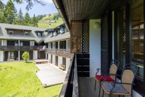 a balcony of a house with chairs on it at Apartma Krvavec - cosy mountain retreat in Cerklje na Gorenjskem