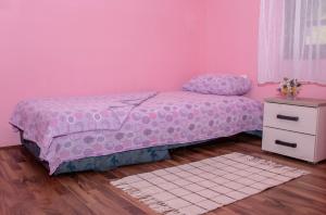 een roze slaapkamer met een bed en een dressoir bij Raj na selu - Padaberi paradise in Berane