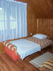 een slaapkamer met een bed en een raam bij Raj na selu - Padaberi paradise in Berane