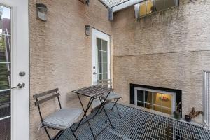 費城的住宿－Beautiful 1BD With Balcony Hosted By StayRafa - 2F，庭院设有两把椅子、一张桌子和一个壁炉