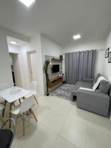 Apartamento em condomínio 24 hrs في خوازيرو دو نورتي: غرفة معيشة مع أريكة وطاولة