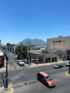 a red car is driving down a city street at Casa Nórdica - Monterrey in Monterrey