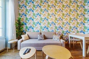 sala de estar con sofá y papel pintado con motivos florales en Le Tolstoï charmant 4 pers Villeurbanne, en Villeurbanne