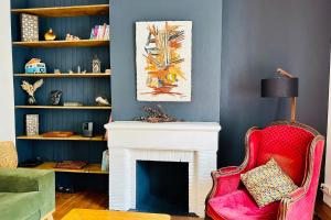 a living room with a fireplace and a red chair at Nice apartment with wifi near town center and Wine Museum in Bordeaux