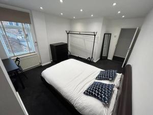 a bedroom with a bed with two pillows on it at Modern & Bright 4 Bedroom Home in Stoke on Trent