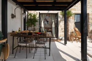 un patio al aire libre con mesa y sillas en Blacksmith's House - rental house with heated pool, en Posedarje