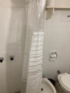 a bathroom with a toilet and a shower curtain at La Casita in La Cumbre