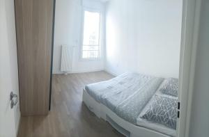 ein weißes Schlafzimmer mit einem Bett und einem Fenster in der Unterkunft Magnifique T2 proche gare in Rueil-Malmaison