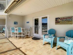 a porch with blue chairs and a table and chairs at Clearwater Penthouse 5 min Beach walk Heated Pool in Clearwater Beach